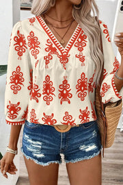Ivory blouse with red embroidery, V-neck, 3/4 sleeves, and contrast trim.