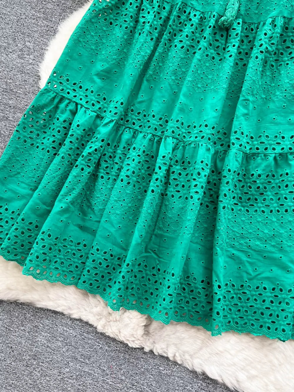 Green eyelet tiered maxi skirt with cutout details and a drawstring waist.