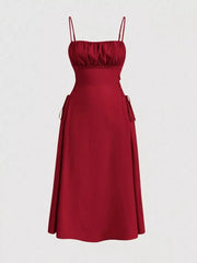 Deep red cami dress with ruched bodice and crisscross lace-up sides, A-line skirt.