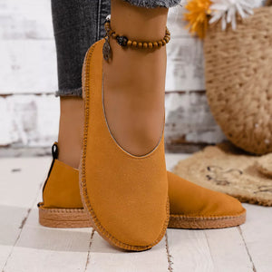 Yellow suede round toe comfort flats with stitched trim and a low sole.