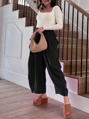 Black linen balloon trousers with cargo pockets and a relaxed fit.