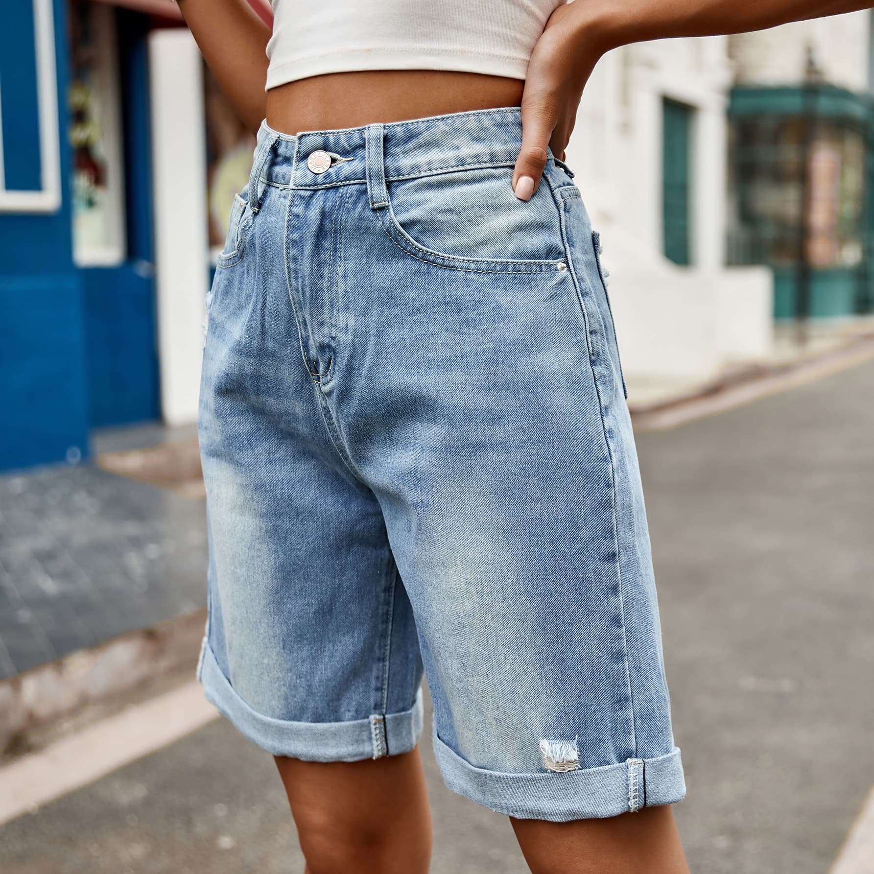 Rolled hem boyfriend denim shorts in medium wash with distressed detail.
