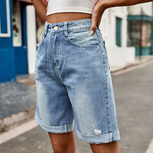 Rolled hem boyfriend denim shorts in medium wash with distressed detail.