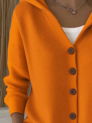 Orange hooded knit cardigan with button front and white t-shirt layer.