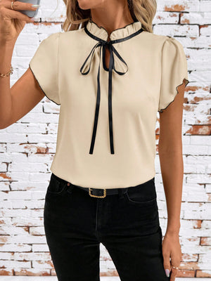 Apricot frilled tie-neck maternity blouse with black trim and bow detail.