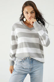 Gray and white striped V-neck relaxed knit sweater with long sleeves.