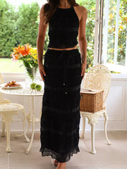 Black halter neck smocked two-piece maternity swim dress with tiered skirt and beaded details.