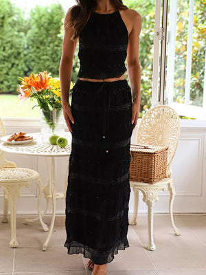 Black halter neck smocked two-piece maternity swim dress with tiered skirt and beaded details.