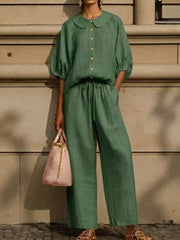 Green two-piece set with pocketed top, Peter Pan collar, puff sleeves, and drawstring pants.