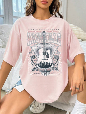 Blush pink oversized graphic tee with Nashville Music City guitar and skyline print