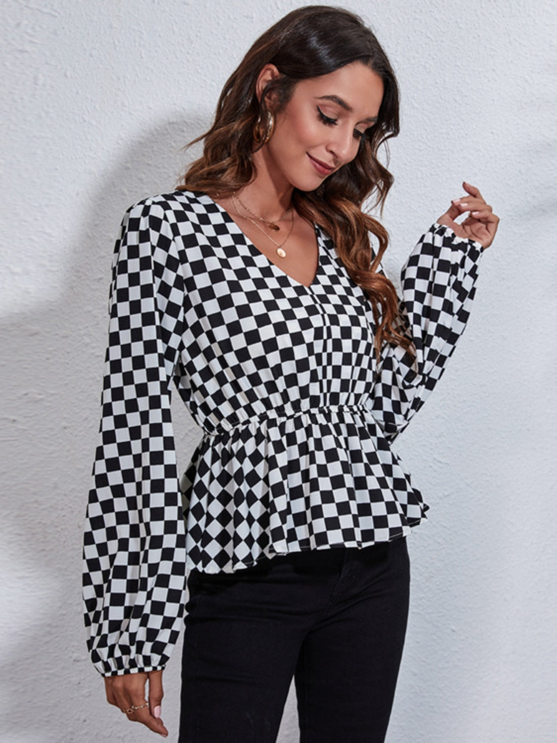 Black and white checkered peplum blouse with gathered waist and V-neck