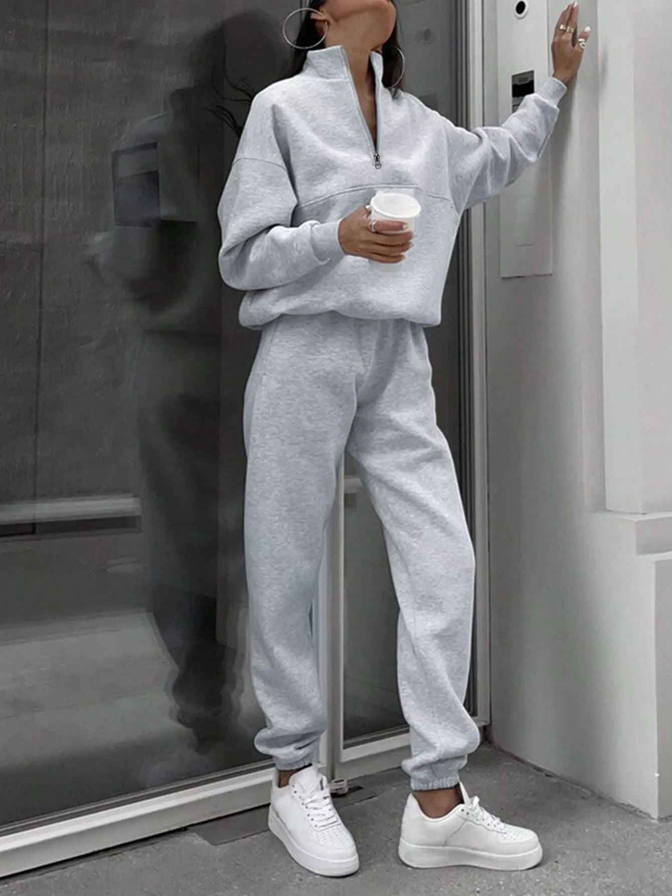 Light gray half zip sweatshirt and jogger pants set with a relaxed fit.