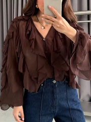 Brown sheer long-sleeve blouse with ruffled details and V-neck.