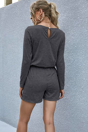 Dark gray jersey romper with long sleeves, elastic waist, and keyhole back detail.