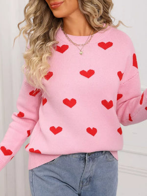 Pink acrylic knit sweater with a red heart print, crew neck, and long sleeves.
