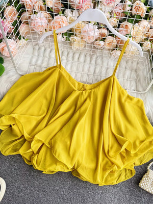 Yellow ruffled camisole with spaghetti straps and a flowy, layered hem.