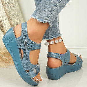 Sky blue textured wedge sandals with adjustable straps and contrast stitching.