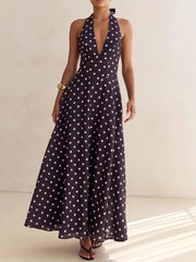 Maxi dress with halter neck, deep V-neck, and polka dot pattern in dark blue.