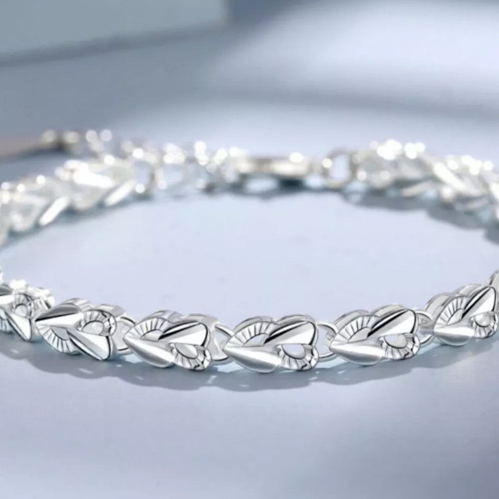 Sterling silver bracelet with interconnected heart links and a clasp closure.