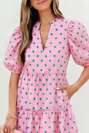 Pink polka dot mini dress with tiered skirt, puff sleeves, and V-neck.
