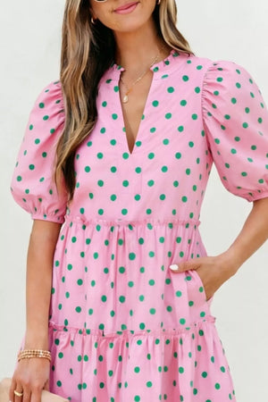 Pink polka dot mini dress with tiered skirt, puff sleeves, and V-neck.