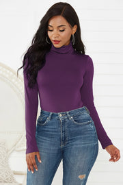 Sculpted turtleneck bodysuit in deep purple with long sleeves, paired with blue jeans.