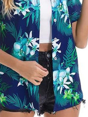 Tropical hibiscus print button-up shirt in dark blue with white and green flowers and leaves.