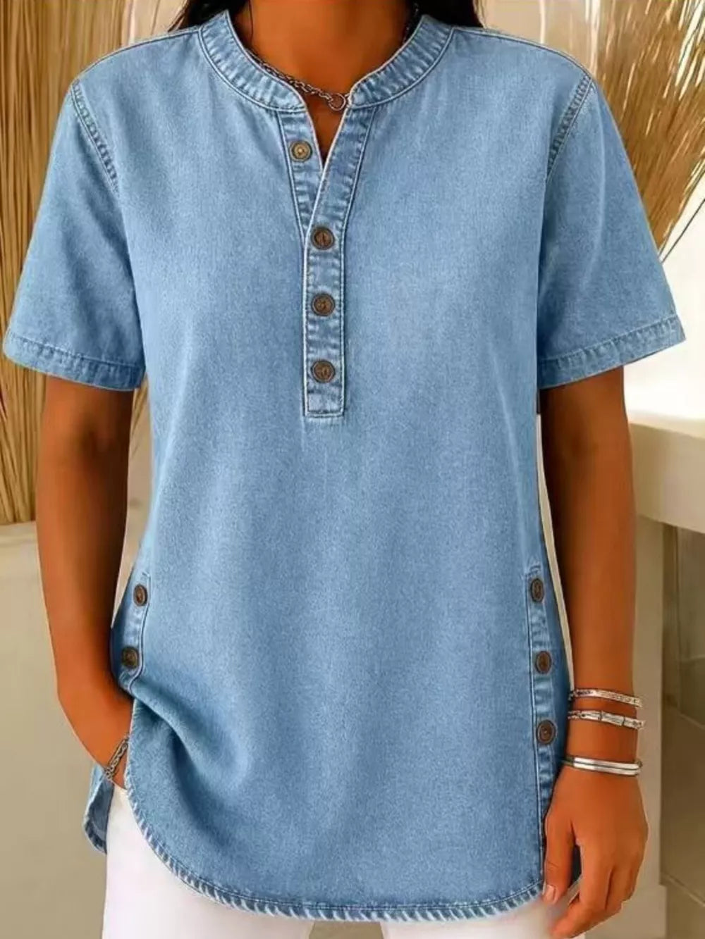 Light blue denim-inspired short sleeve button blouse with mandarin collar and side button detail.