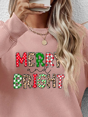 Blush pink crewneck sweatshirt with "Merry and Bright" graphic in festive patterns.