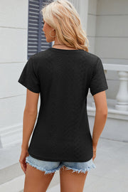 Black eyelet wrap v-neck top with short sleeves and a textured pattern.