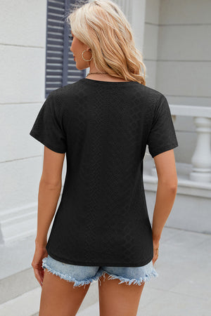 Black eyelet wrap v-neck top with short sleeves and a textured pattern.