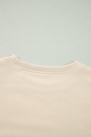 Cream sweatshirt with ribbed neckline and subtle shoulder ruffles.