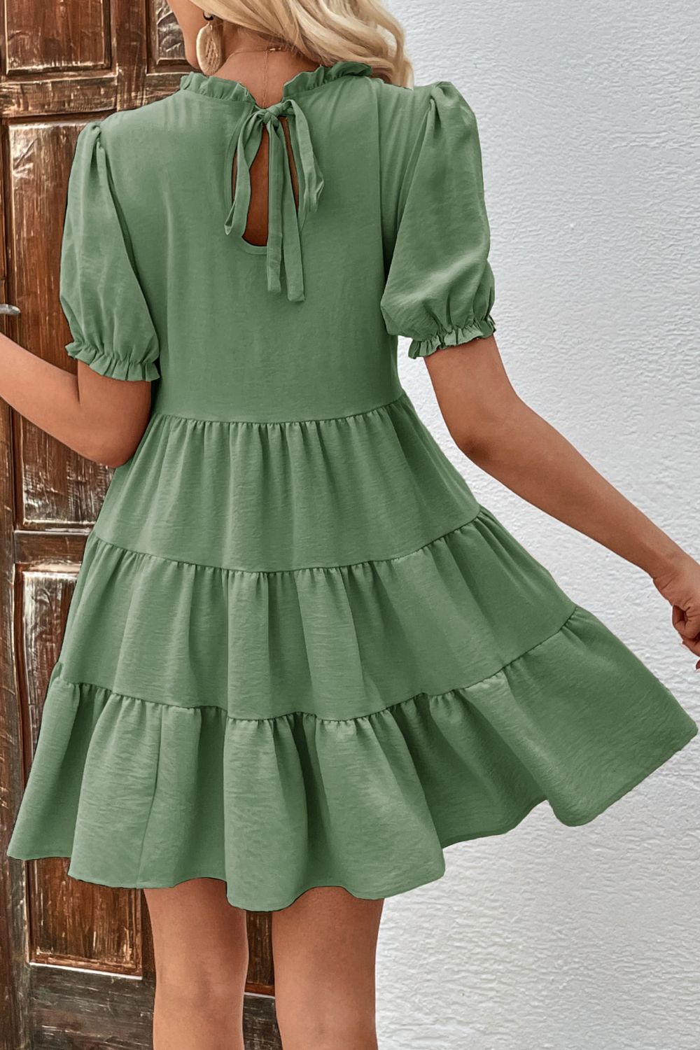 Matcha green tiered mini dress with ruffled neckline, puff sleeves, and back tie.
