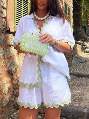 White collared pajama set with green scalloped trim and matching shorts.