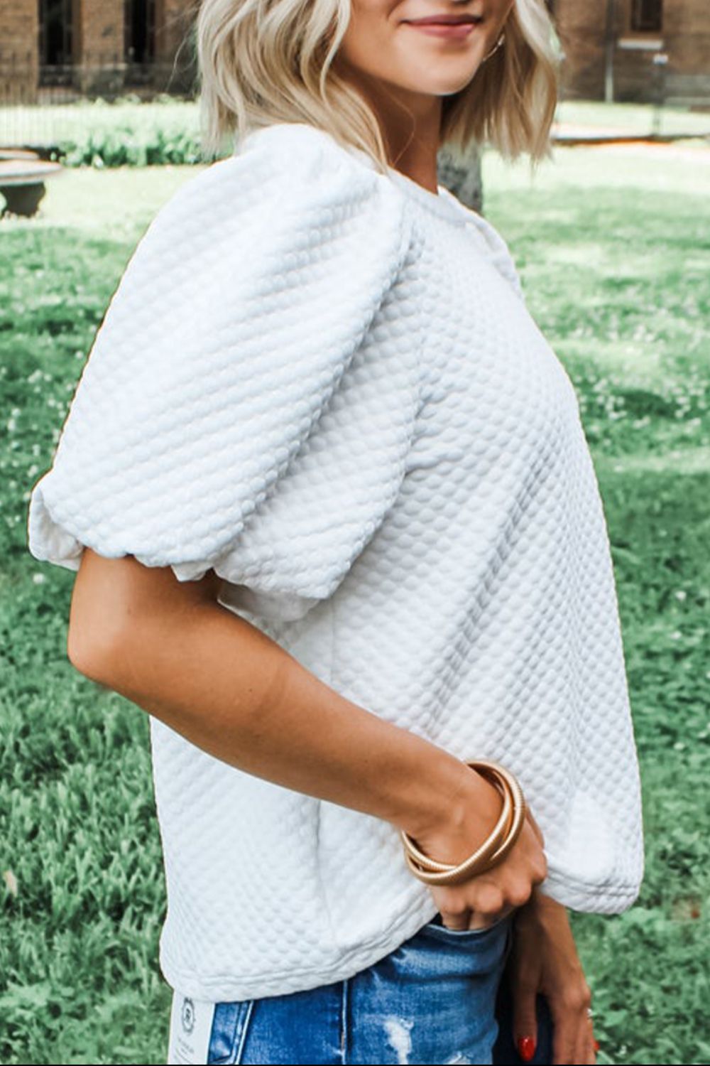 Textured white quilted puff sleeve blouse with scalloped cuffs.