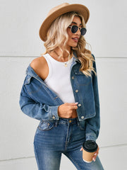 Cropped denim trucker jacket in dusty blue with button closure and chest pockets.