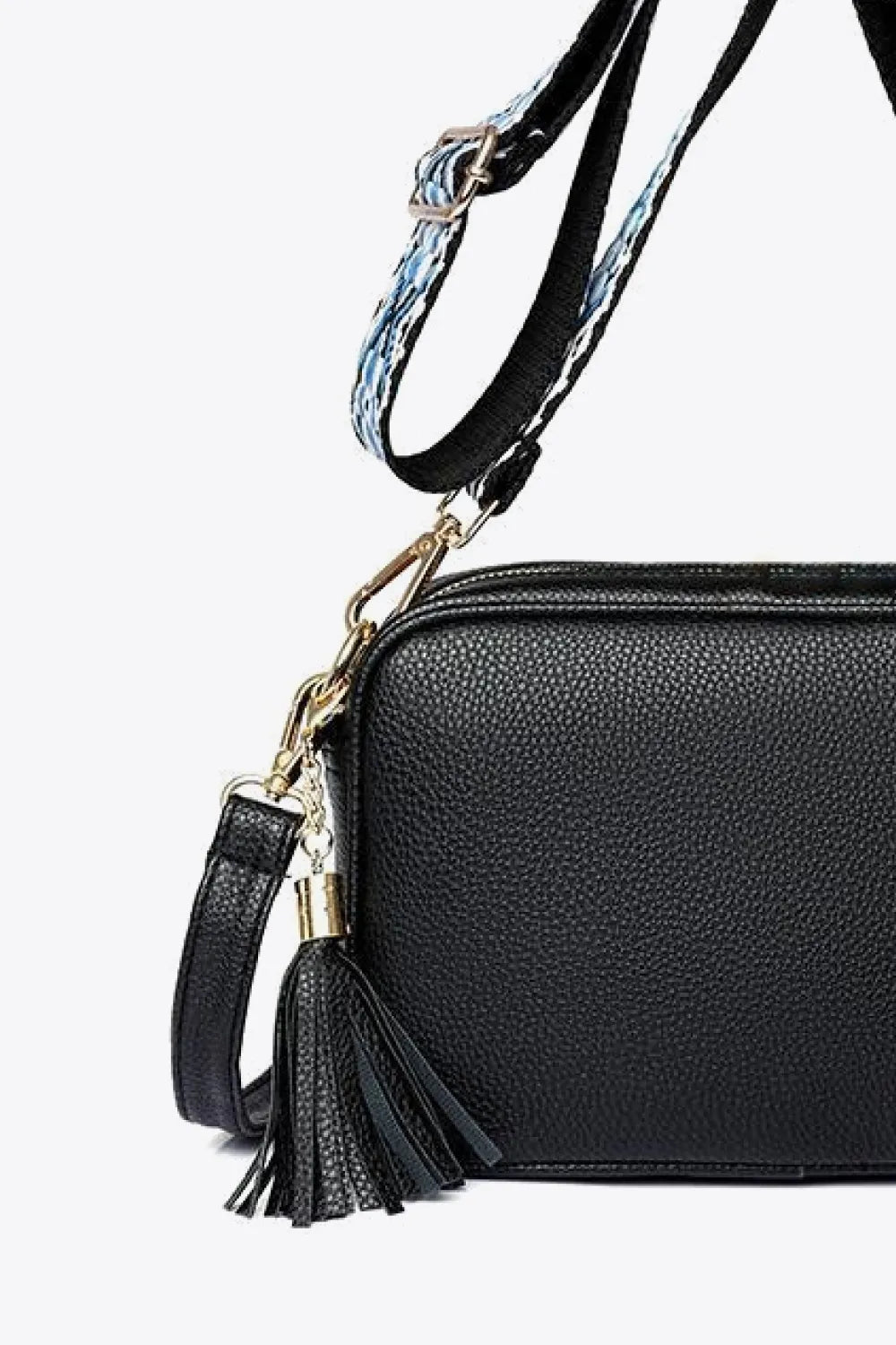Black textured crossbody bag with tassel detail and patterned strap