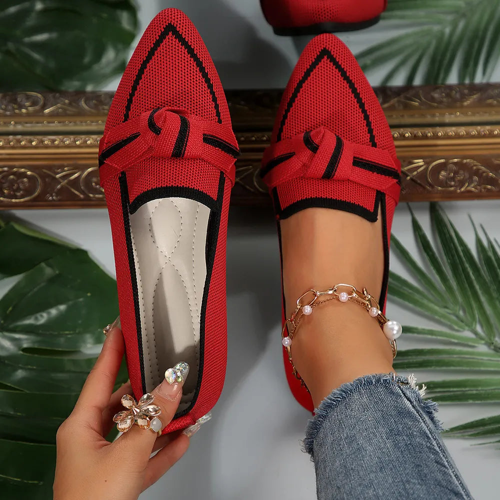 Red mesh pointe slip-on flats with black trim and bow detail.