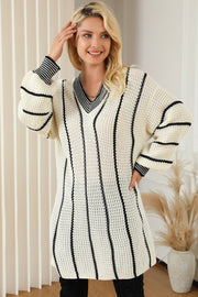 Ivory knit oversized V-neck dress with black vertical stripes and striped cuffs.