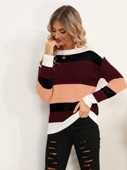 Colorblock crewneck knit sweater with horizontal stripes in burgundy, peach, black, and white.