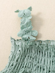 Green cotton eyelet tank top with smocking and floral strap detail.
