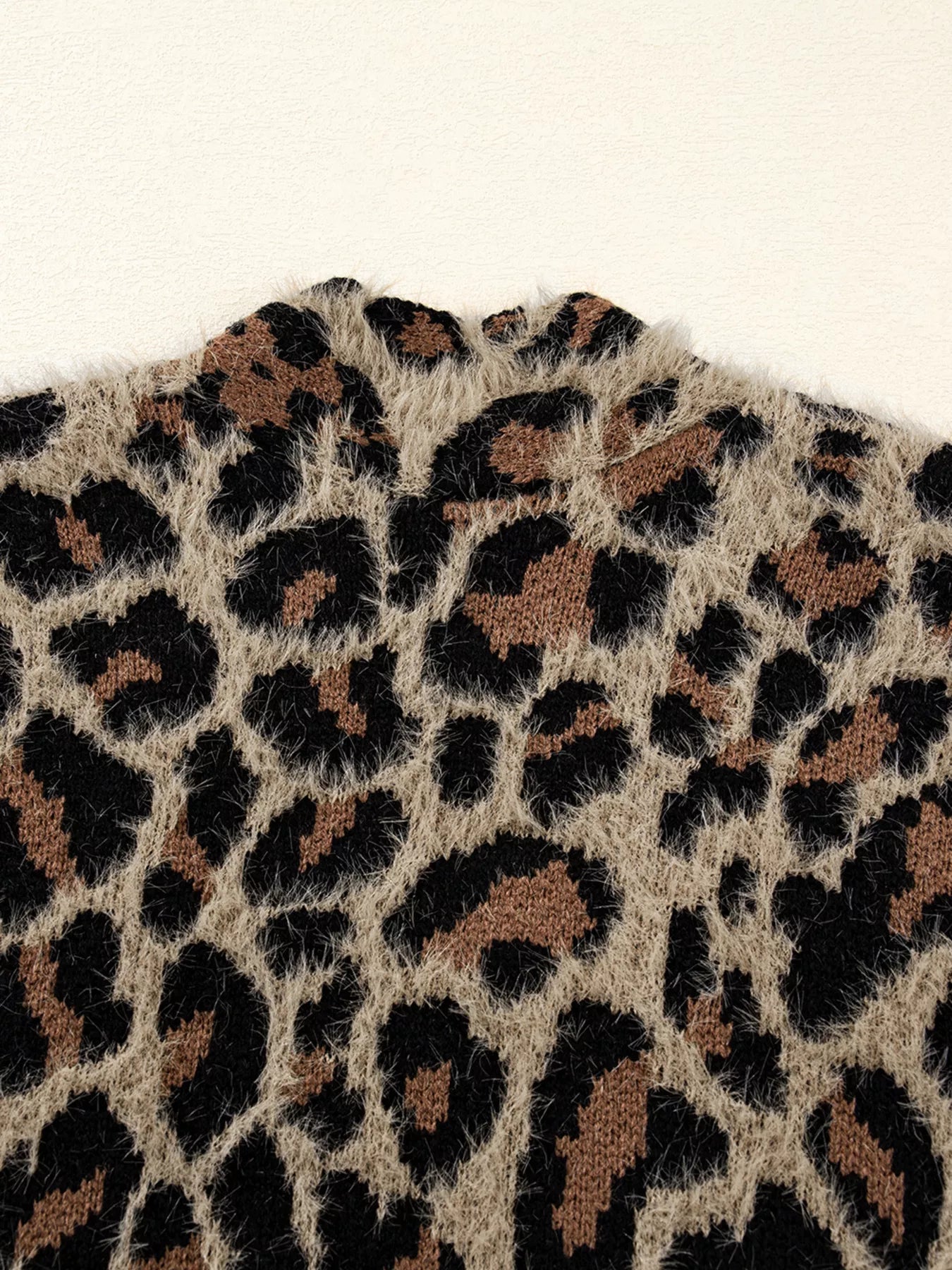 Leopard print fuzzy knit cardigan with a mock neck detail.