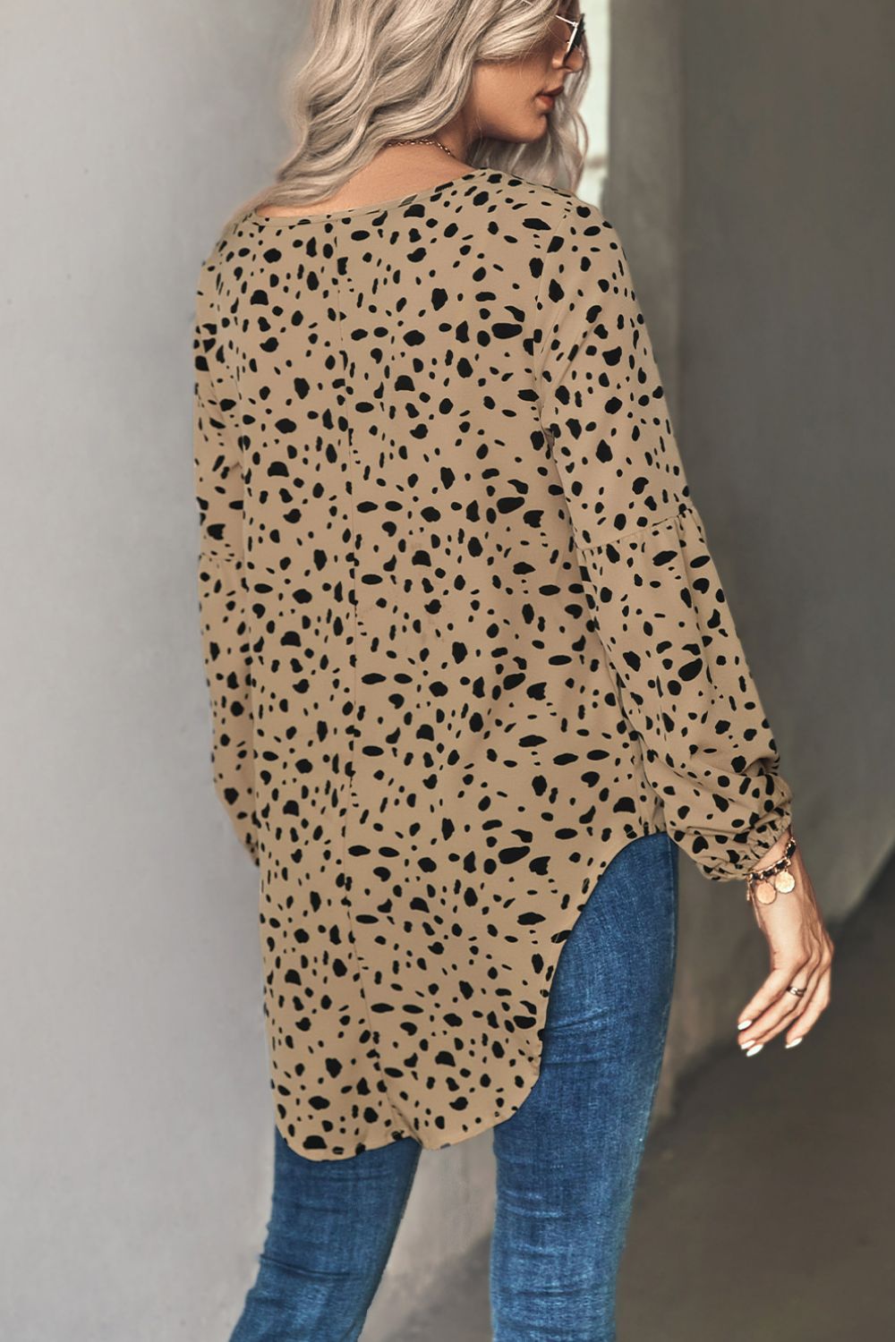 Khaki Dalmatian print blouse with balloon sleeves and a curved hem.