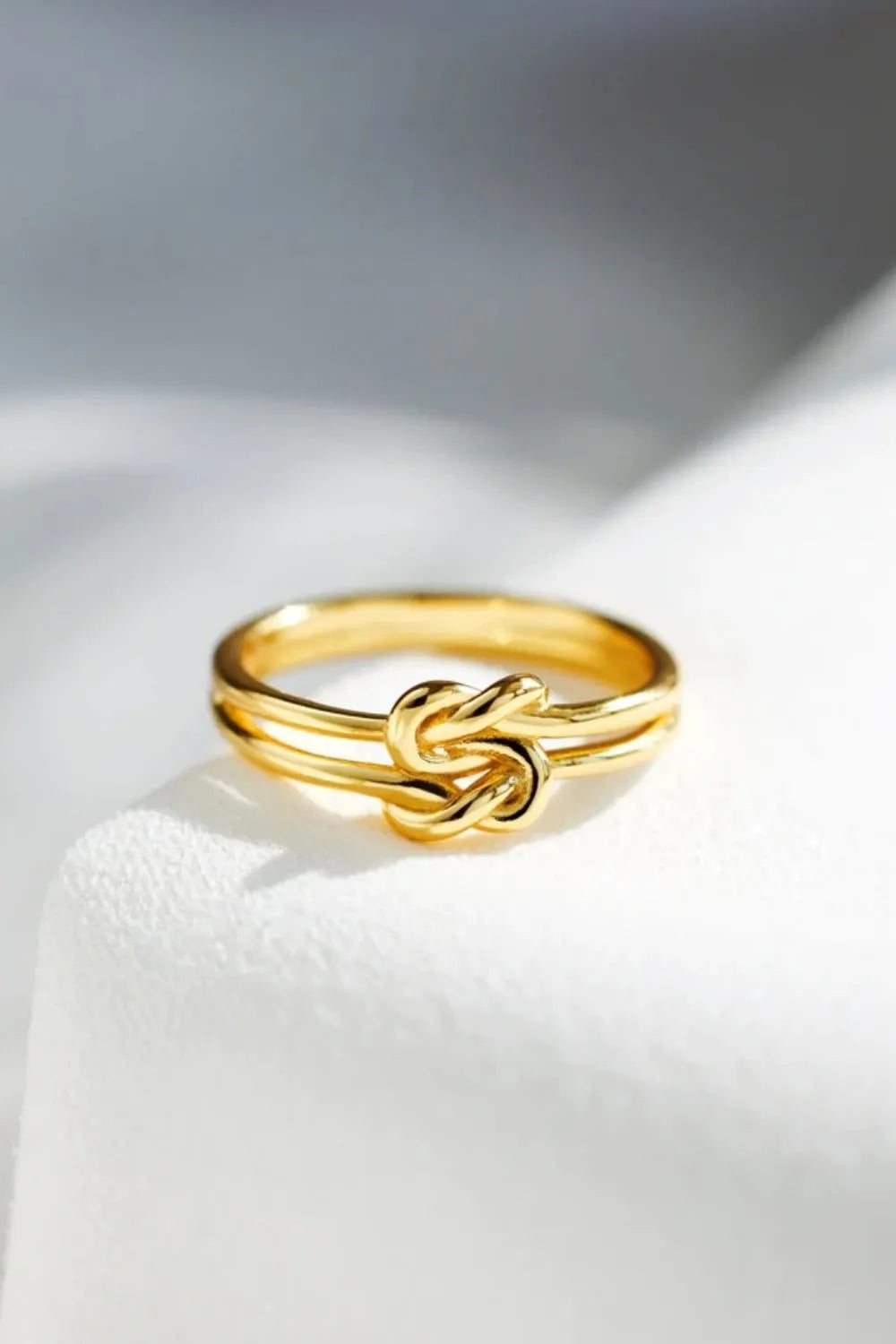 Gold double band knot ring with a minimalist design.