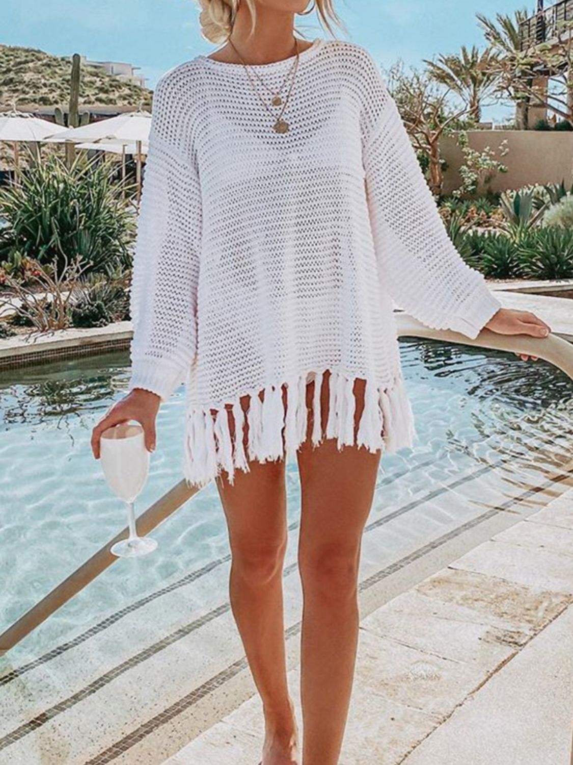 White open-knit acrylic beach cover-up with fringe hem, long sleeves and crew neck.