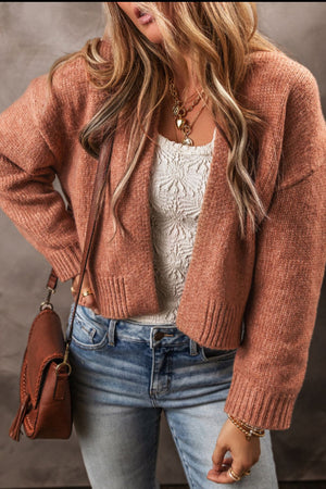 Open-front cropped knit cardigan in burnt coral acrylic with ribbed cuffs and hem.