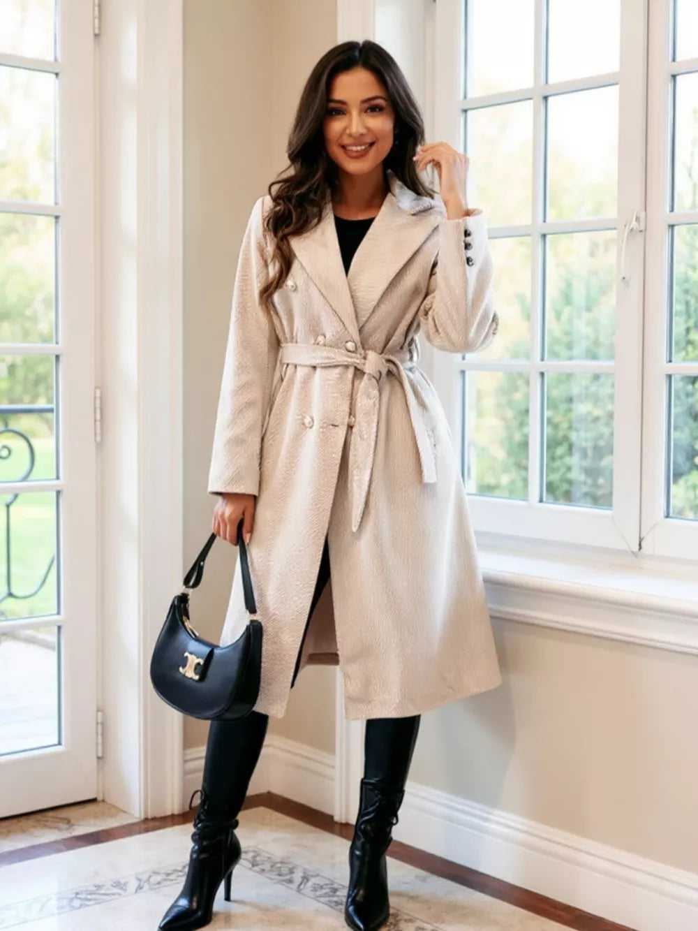 Apricot tailored double-breasted trench coat with waist tie and button details.
