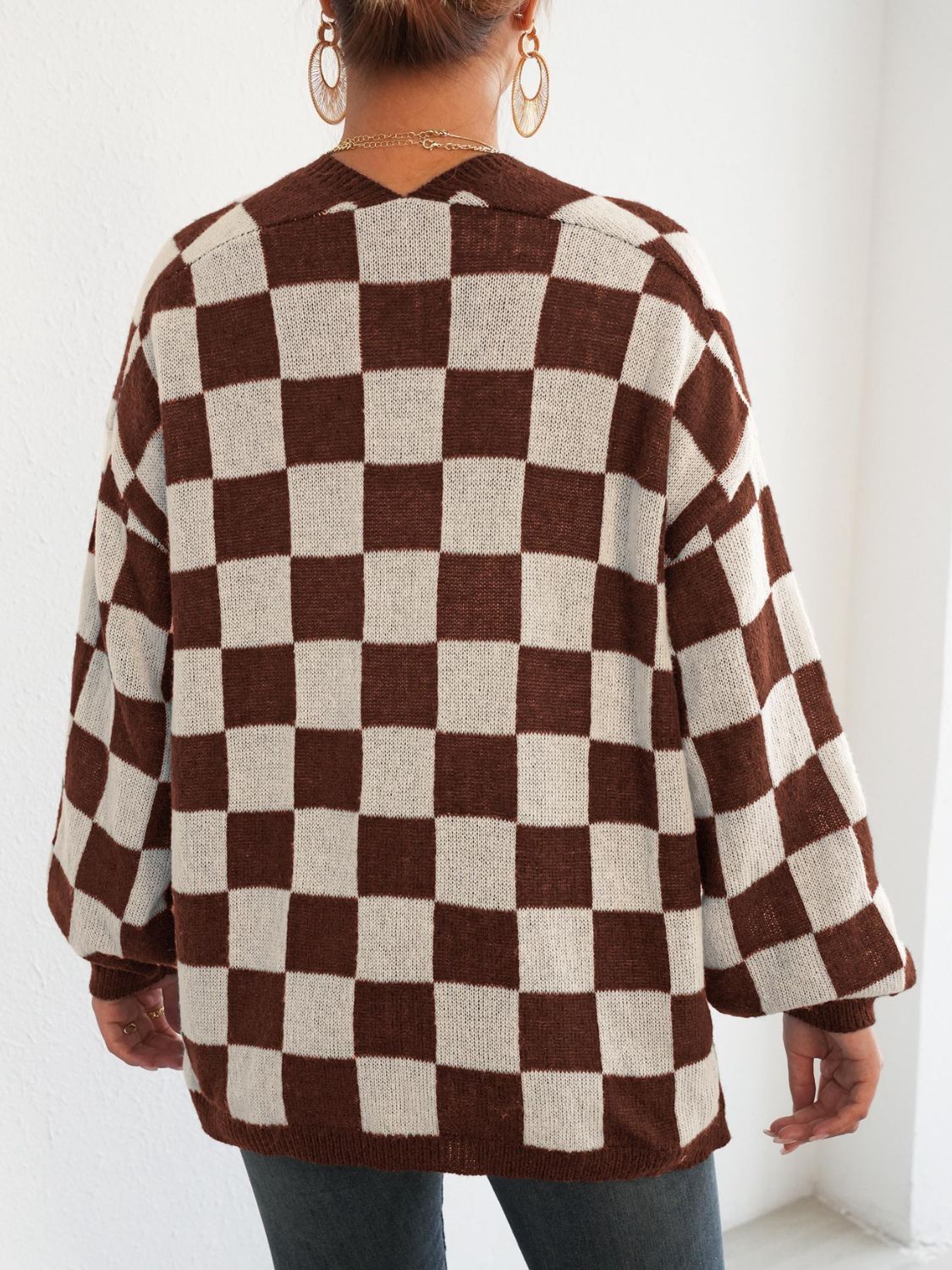 Checkerboard knit cardigan in brown and white with balloon sleeves and a V-neck.