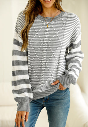 Gray and white geometric stripe knit sweater with crew neck and long sleeves.