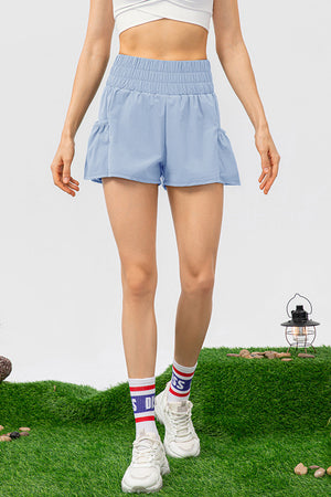 Light blue active shorts with gathered waistline and ruffled pockets.